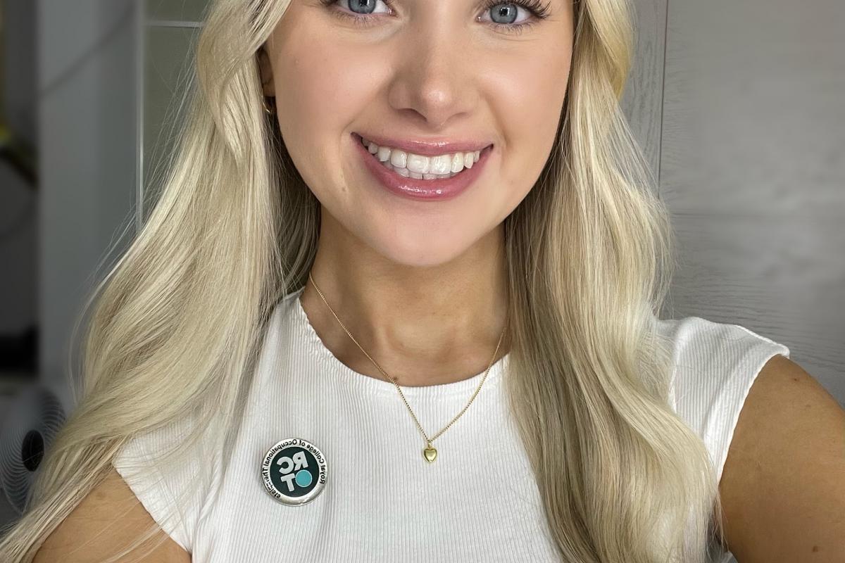 headshot of young girl with blonde hair and RCOT member badge