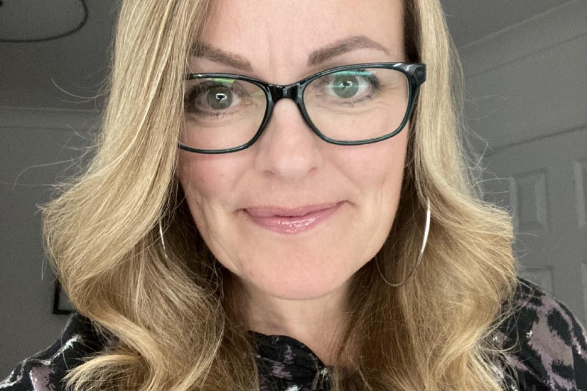 Sarah smiling up close with black framed glasses