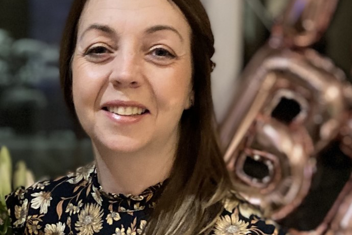 Lorraine smiling with a black and gold blouse