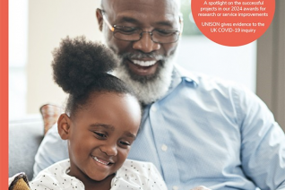 Front cover of October issue of OTnews a black grandfather reading a story to a young black child