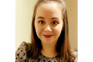 A woman smiles at the camera